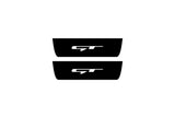 Catalog illustration of two black rear door sill plates with GT lettering.