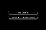 Two long door sill plates with Koleos lettering and edges illuminated in white, straight-on view on a dark background.
