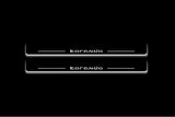 Two long door sill plates with Korando lettering and edges illuminated in white, straight-on view on a dark background.
