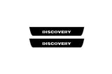 Catalog illustration of two black rear door sill plates with Discovery lettering.