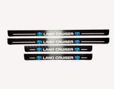 Toyota LC 200 2007+ illuminated entry guards in stainless steel with Land Cruiser logo