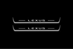 Two long door sill plates with Lexus lettering and edges illuminated in white, straight-on view on a dark background.