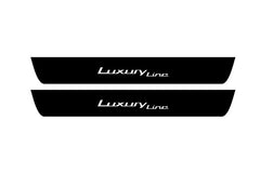 Catalog illustration of two black front door sill plates with Luxury Line lettering.