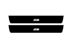 Catalog illustration of two black front door sill plates with ///M lettering.