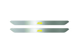 Catalog illustration of two narrow silver door sill inserts with yellow striped M emblems on a white background.