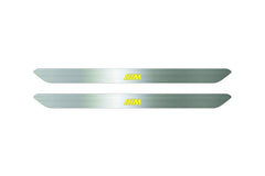 Catalog illustration of two narrow silver door sill inserts with yellow striped M emblems on a white background.