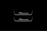 Two short door sill plates with Macan lettering and edges illuminated in white, straight-on view on a dark background.
