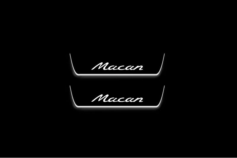 Two short door sill plates with Macan lettering and edges illuminated in white, straight-on view on a dark background.