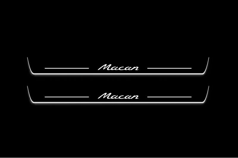 Two long door sill plates with Macan lettering and edges illuminated in white, straight-on view on a dark background.