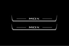 Two long door sill plates with MDX lettering and edges illuminated in white, straight-on view on a dark background.