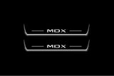 Two long door sill plates with MDX lettering and edges illuminated in white, straight-on view on a dark background.