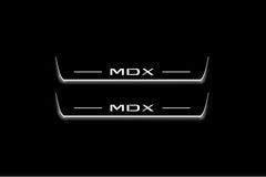 Two long door sill plates with MDX lettering and edges illuminated in white, straight-on view on a dark background.