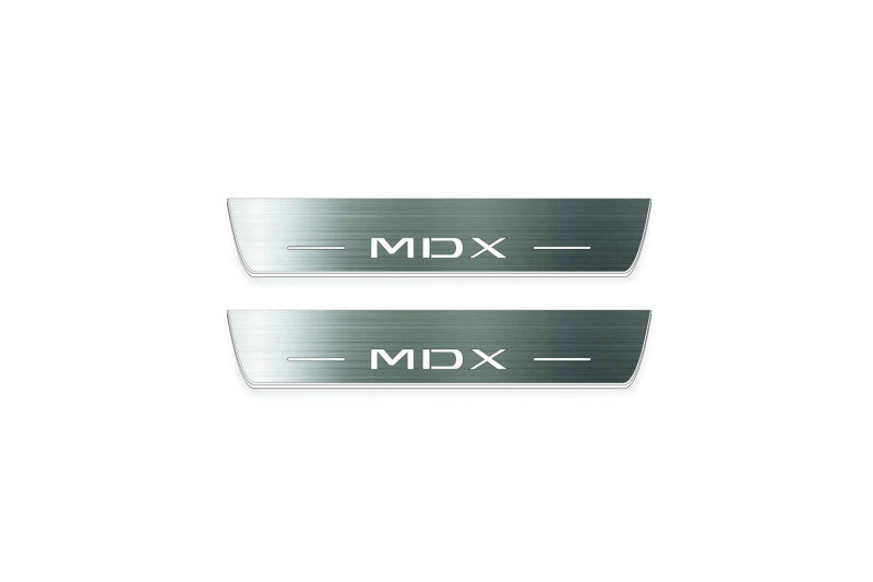 Two short silver-finished door sill plates with MDX lettering on a light background, straight-on view.
