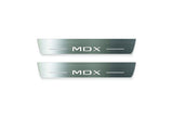 Two long silver-finished door sill plates with MDX lettering on a light background, straight-on view.