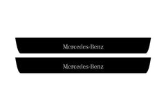 Catalog illustration of two black front door sill plates with Mercedes-Benz lettering.
