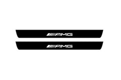 Catalog illustration of two black front door sill plates with AMG lettering.