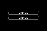 Two long door sill plates with Meriva lettering and edges illuminated in white, straight-on view on a dark background.