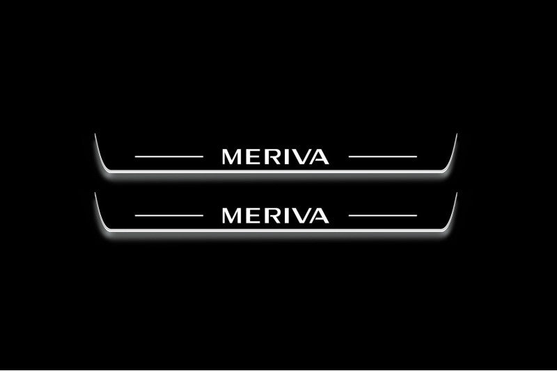 Two long door sill plates with Meriva lettering and edges illuminated in white, straight-on view on a dark background.