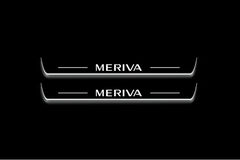 Two long door sill plates with Meriva lettering and edges illuminated in white, straight-on view on a dark background.