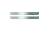 Two short silver-finished door sill plates with Meriva lettering on a light background, straight-on view.