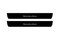 Catalog illustration of two black front door sill plates with Mercedes-Benz lettering.
