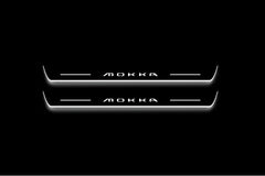 Two long door sill plates with Mokka lettering and edges illuminated in white, straight-on view on a dark background.