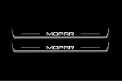 Two long door sill plates with Mopar lettering and edges illuminated in white, straight-on view on a dark background.
