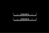 Two short door sill plates with Navara lettering and edges illuminated in white, straight-on view on a dark background.