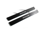 Two black door sill plates with white Rogue lettering and visible wiring on a light background.