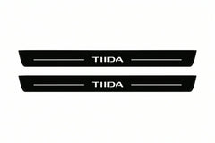Catalogue illustration of two front black Matte PRO LED door sill plates with illuminated TIIDA lettering for Nissan Tiida I C11; dimensions are selected during manufacture.