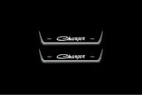 Two short door sill plates with Charger lettering and edges illuminated in white, straight-on view on a dark background.