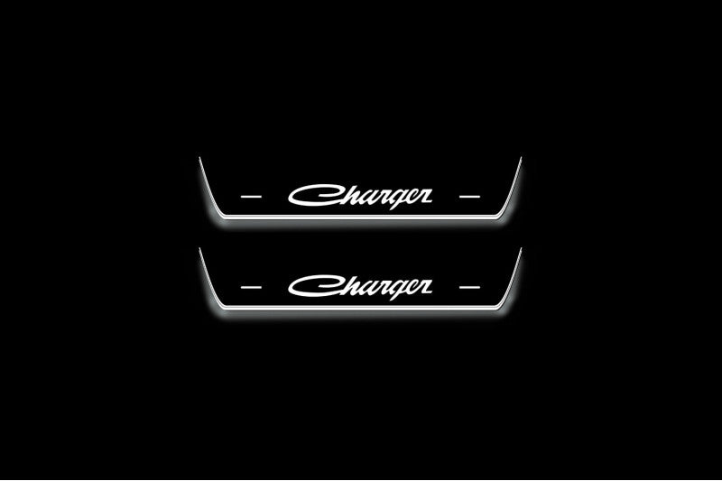 Two short door sill plates with Charger lettering and edges illuminated in white, straight-on view on a dark background.
