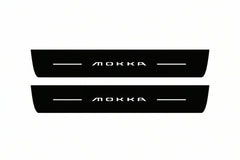 Catalogue illustration of two front black Matte PRO LED door sill plates with illuminated Mokka lettering for Opel Mokka II; dimensions are selected during manufacture.
