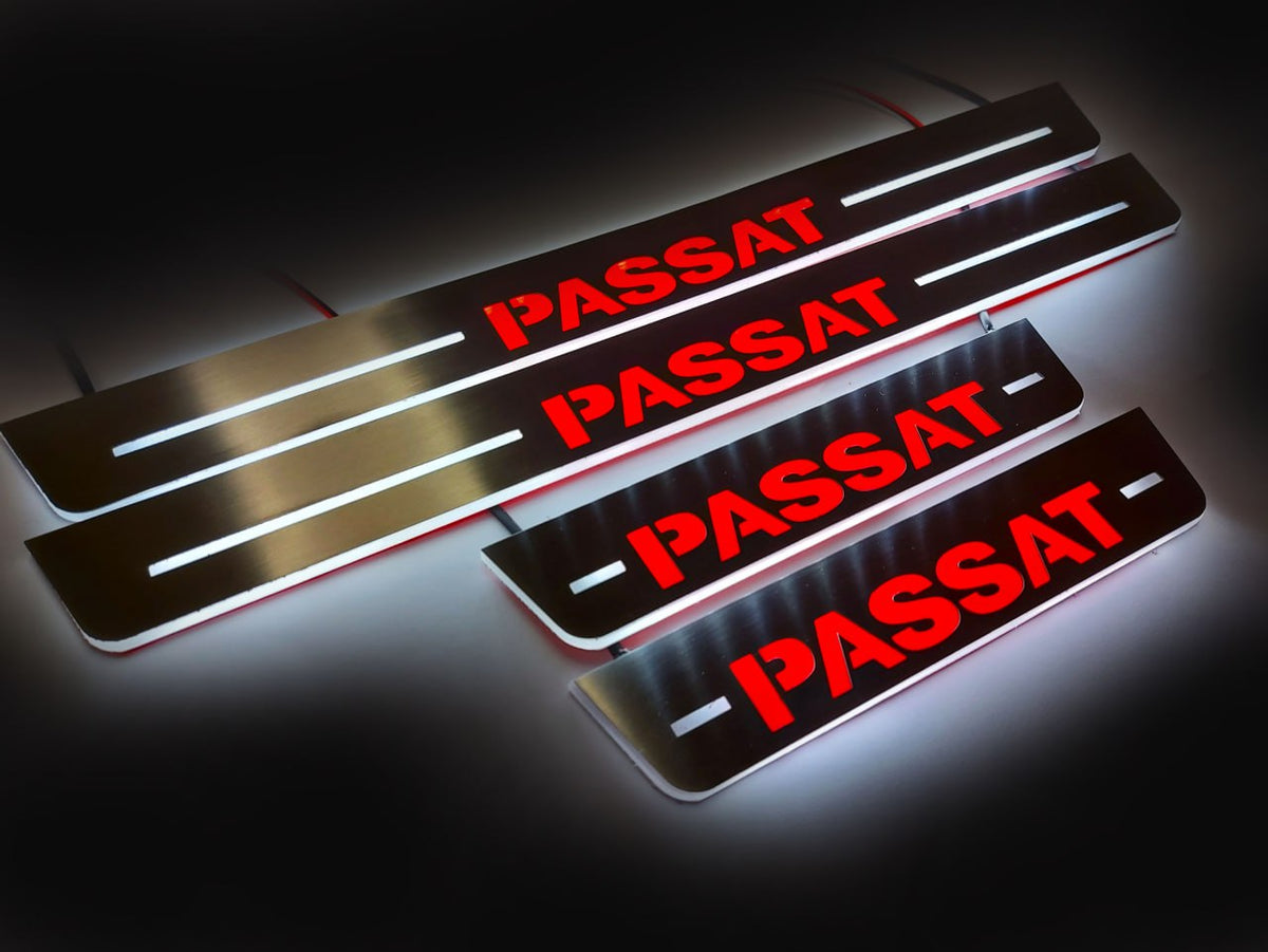 Four wired door sill plates with bold red Passat lettering and white illuminated edges on a dark surface.