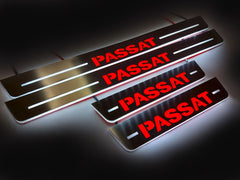 Four wired door sill plates with bold red Passat lettering and white illuminated edges on a dark surface.