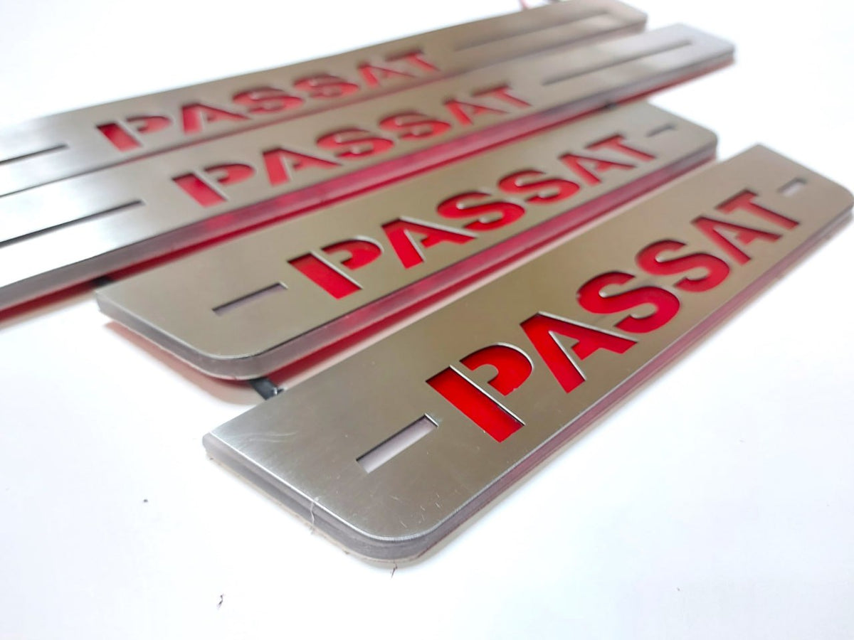 Close-up of bold red Passat lettering and horizontal slots on long and short silver-finished door sill plates.