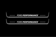 Two long door sill plates with Ford Performance lettering and edges illuminated in white, straight-on view on a dark background.