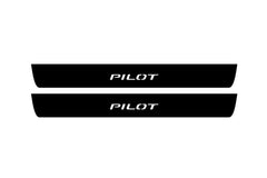 Catalog illustration of two black front door sill plates with Pilot lettering.