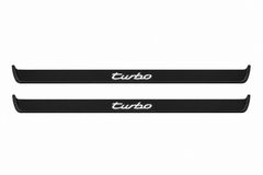 Catalogue illustration of two black Matte PRO front sill plates with illuminated cursive turbo lettering on top. Side edges remain unlit; no rear plates or exact dimensions pictured.