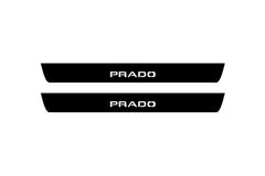 Catalog illustration of two black front door sill plates with Prado lettering.