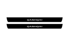 Catalog illustration of two black front door sill plates with Qashqai lettering.