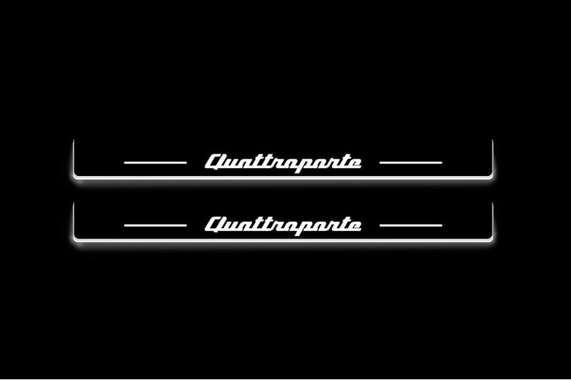 Two long door sill plates with Quattroporte lettering and edges illuminated in white, straight-on view on a dark background.