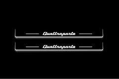 Two long door sill plates with Quattroporte lettering and edges illuminated in white, straight-on view on a dark background.
