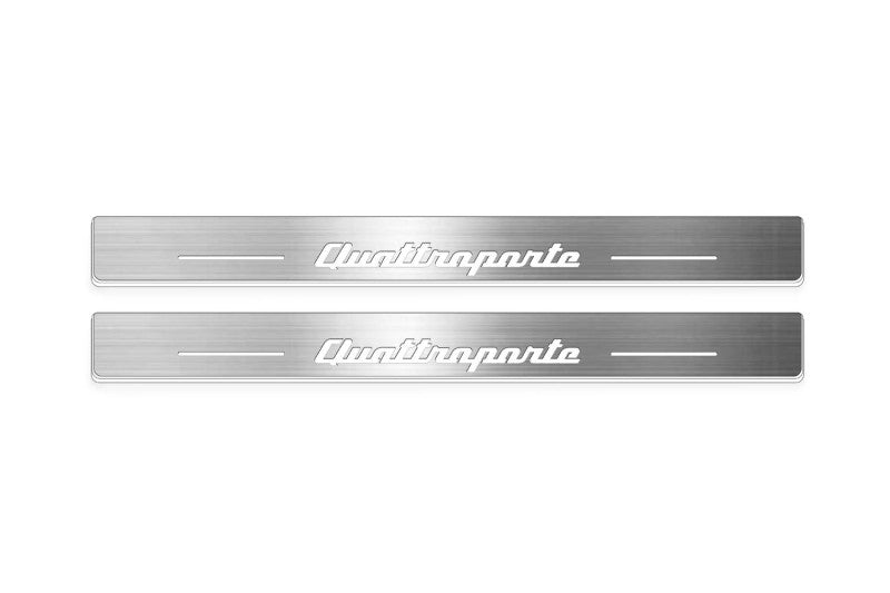 Two long silver-finished door sill plates with Quattroporte lettering on a light background, straight-on view.