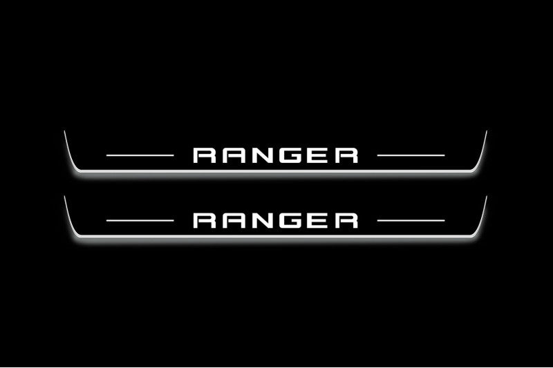Two long door sill plates with Ranger in block lettering lettering and edges illuminated in white, straight-on view on a dark background.