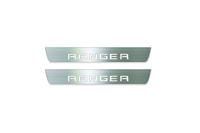 Two short silver-finished door sill plates with Ranger in block lettering lettering on a light background, straight-on view.