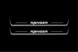 Two long door sill plates with Ranger in angular lettering lettering and edges illuminated in white, straight-on view on a dark background.