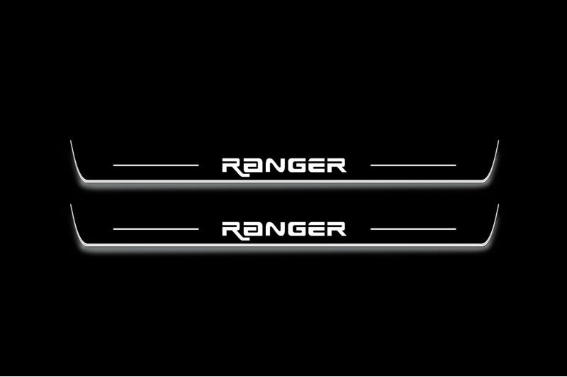 Two long door sill plates with Ranger in angular lettering lettering and edges illuminated in white, straight-on view on a dark background.