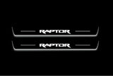 Two long door sill plates with Raptor lettering and edges illuminated in white, straight-on view on a dark background.