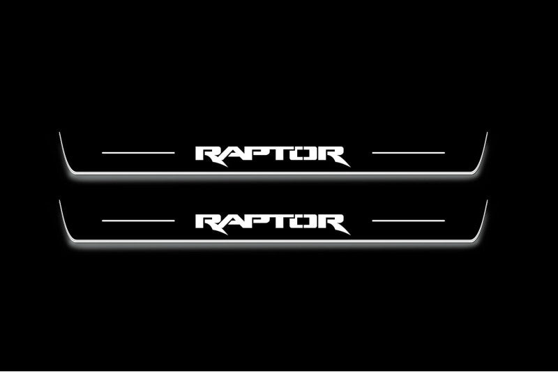 Two long door sill plates with Raptor lettering and edges illuminated in white, straight-on view on a dark background.